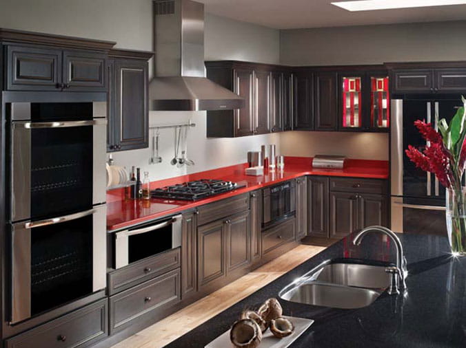Modern kitchen with grey cabinets, red countertops and stainless appliances and fixtures