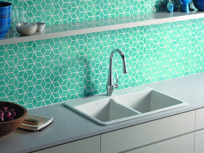 Kohler kithen sink with aqua tiled wall behind it